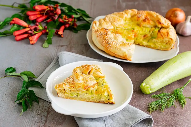 Open pie made of puff pastry with zucchini and cheese